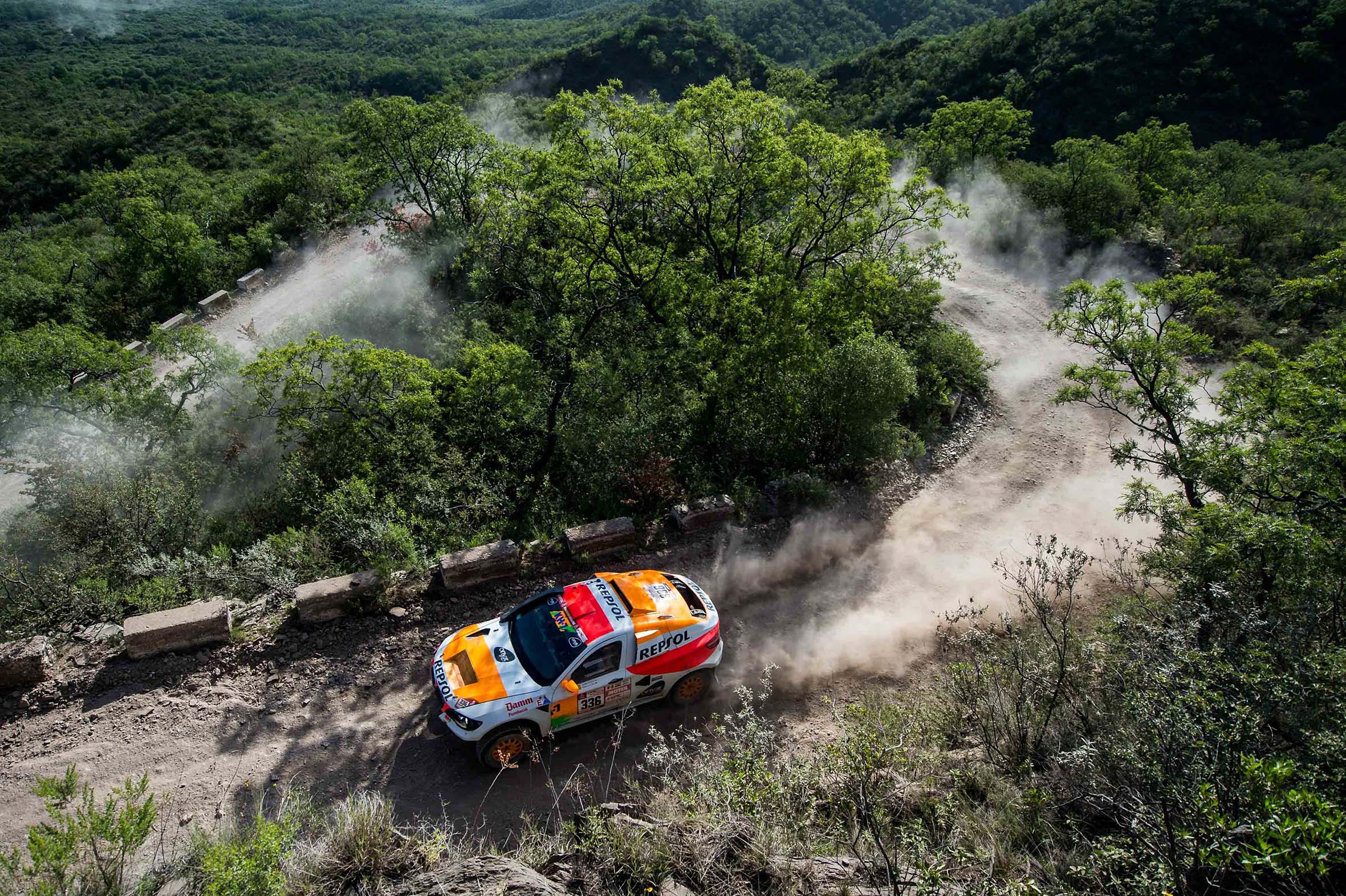 coche rally dakar repsol surcando paisaje boscoso
