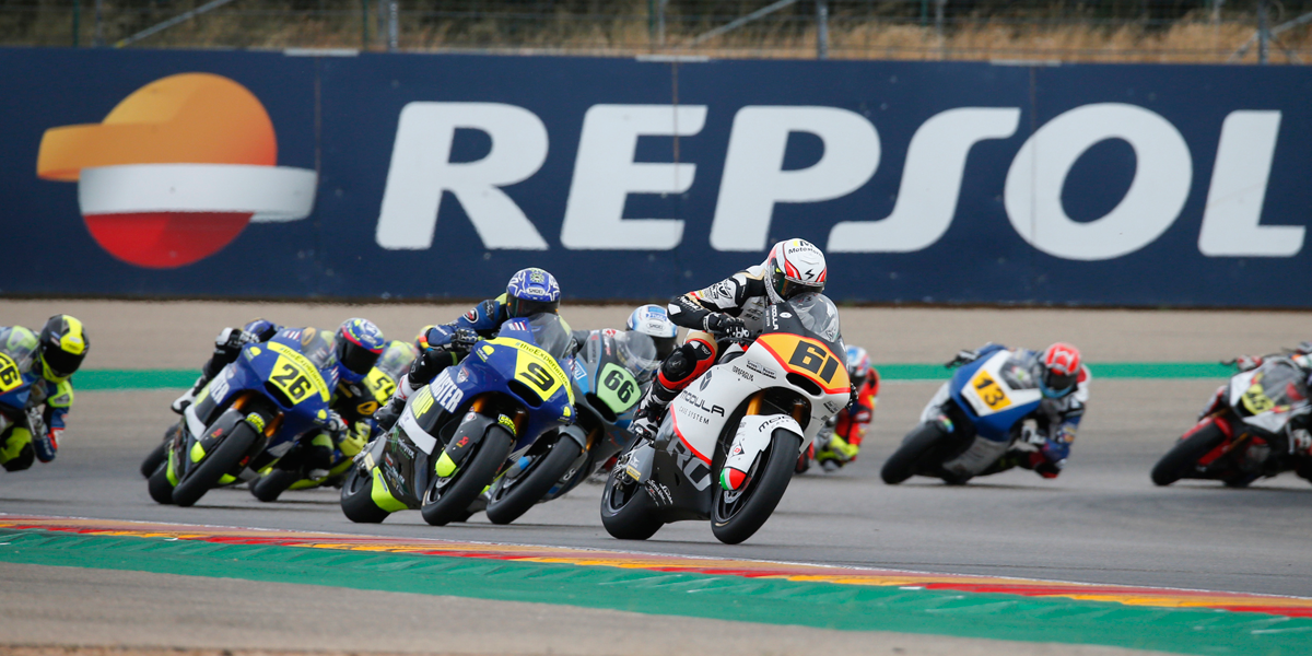 pilotos rodando frente a gran cartel de Repsol
