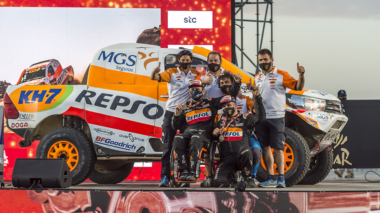 Isidre Esteve junto a su equipo y Toyota Hilux celebrando la llegada en el Dakar 2021 día 12