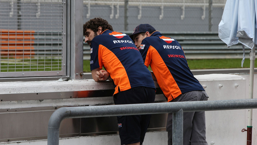 Marc Márquez y Santi Hernádez apoyados en el muro