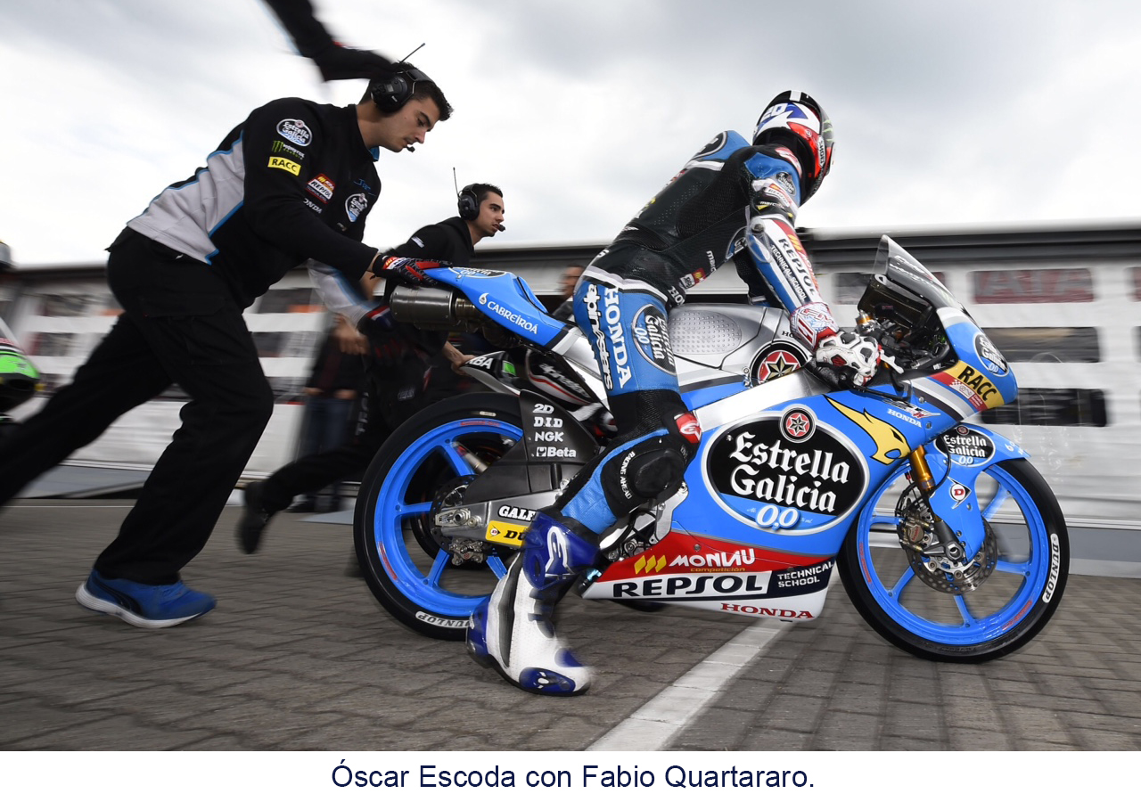 Fabio Quartararo dobre la moto en el pitlane con miembros del equipo
