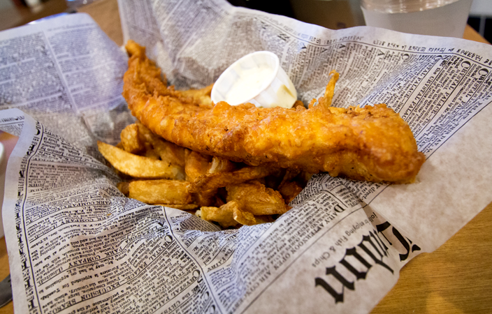 Típico Fish and Chips servido con papel de periódico.
