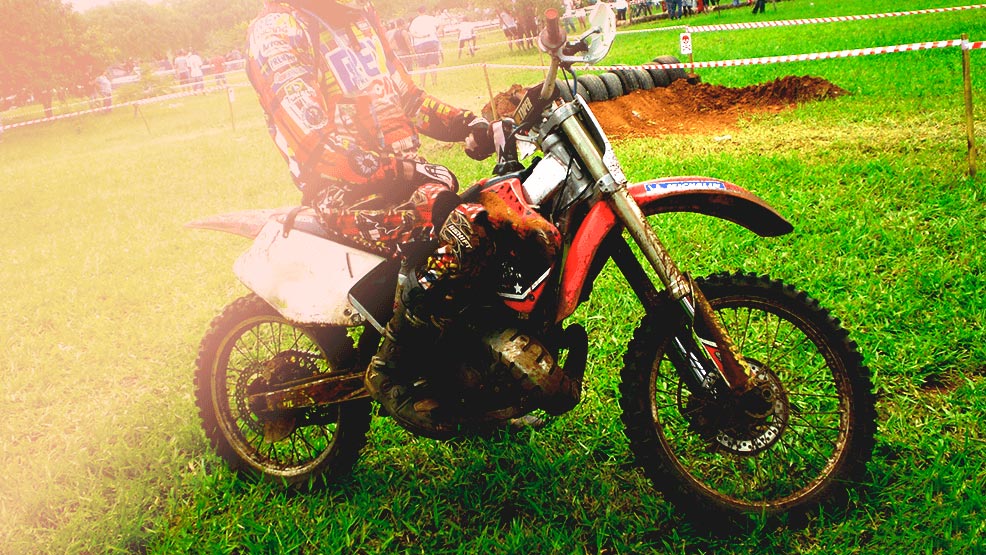 Motorista sobre moto de cross parada