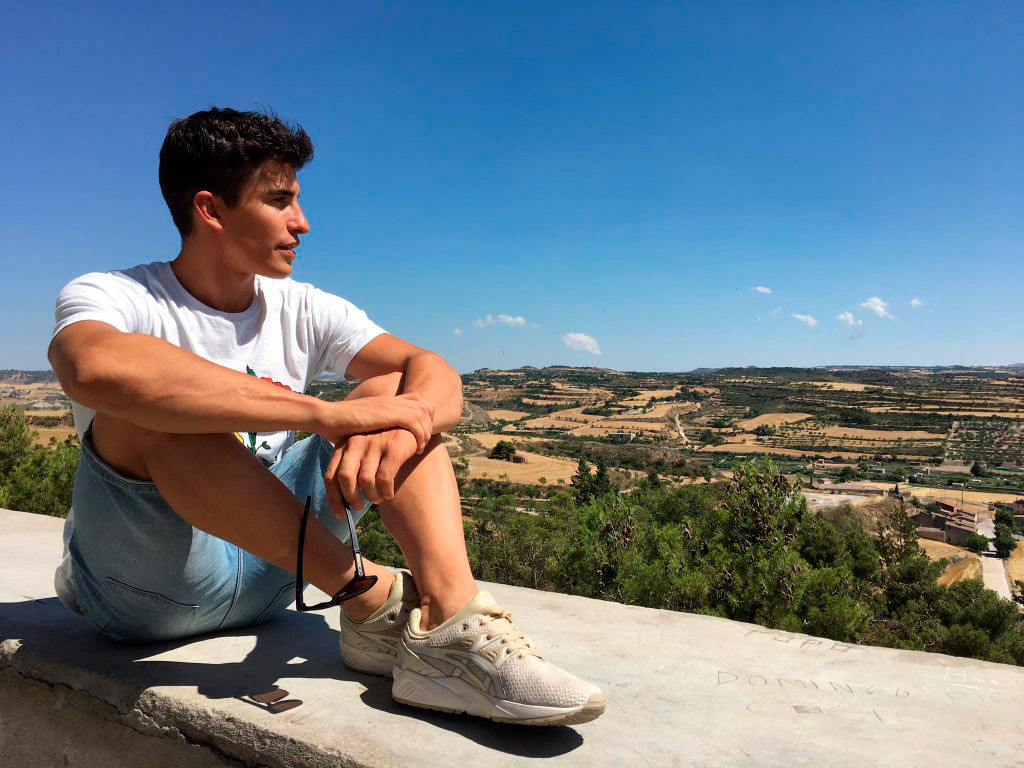 Marc Márquez mirando el paisaje subido a un murete