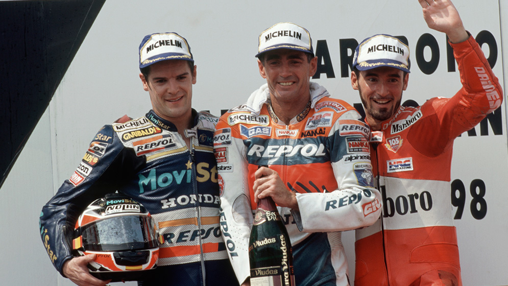 Carlos Checa en el podio junto a Mick Doohan y Max Biaggi