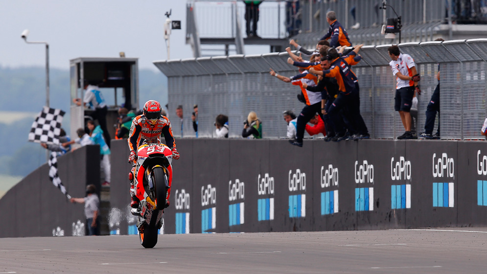 Wheelie de Marc Márquez con su equipo celebrando en la valla