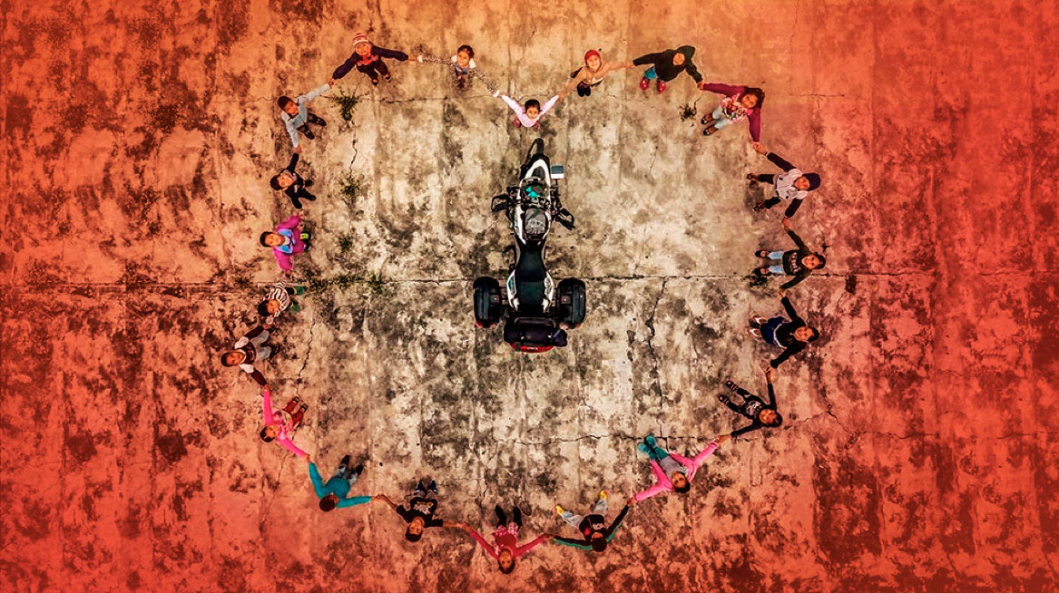 Niños haciendo un corro alrededor de una moto