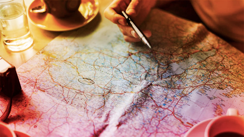 Bolígrafo, mapa de carretera y café