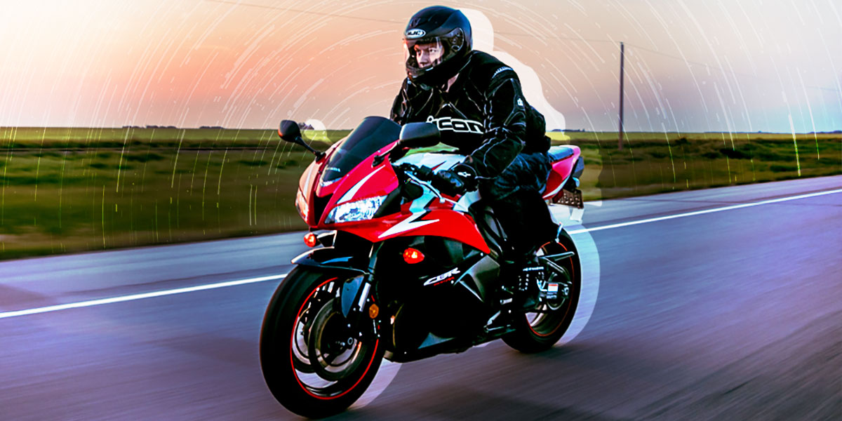 Motero totalmente equipado conduciendo su moto disfrutando de la carretera.