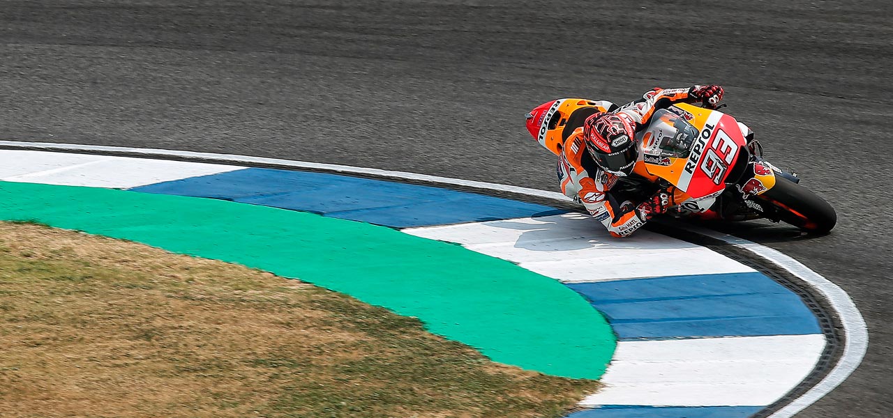 Marc márquez tomando una curva cerrada cerca del piano blanqui-azul