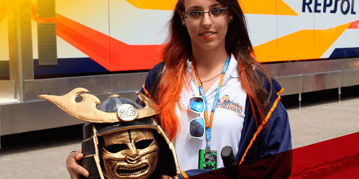 Una fan de Dani Pedrosa en el Paddock sostiene una máscara de Sámurai DIY con el 26 y una katana DIY en su cintura
