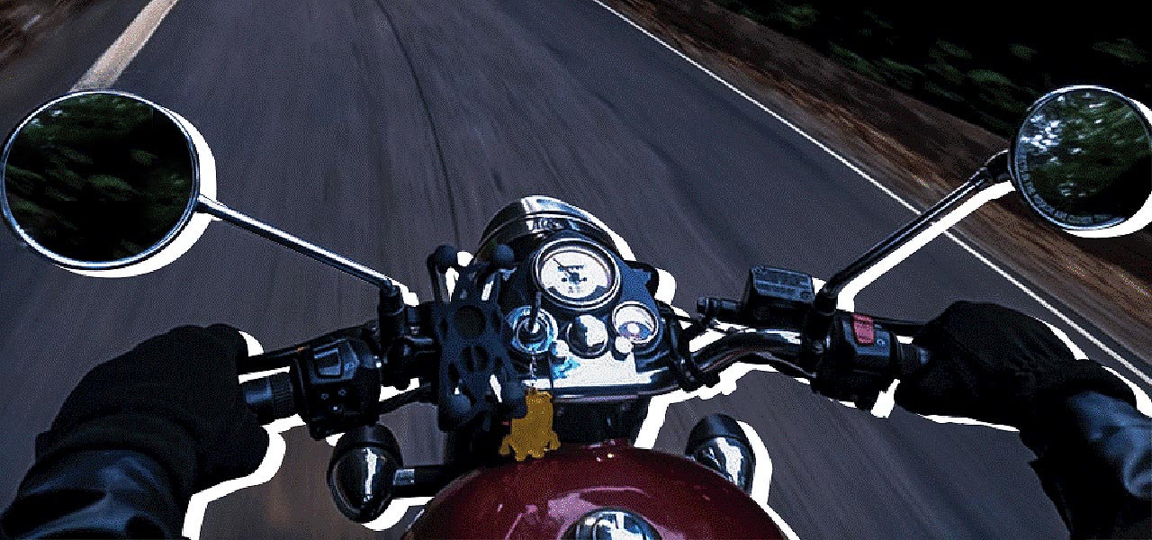 Vista desde la perspectiva de un motero de su manillar y el asfalto frente a él