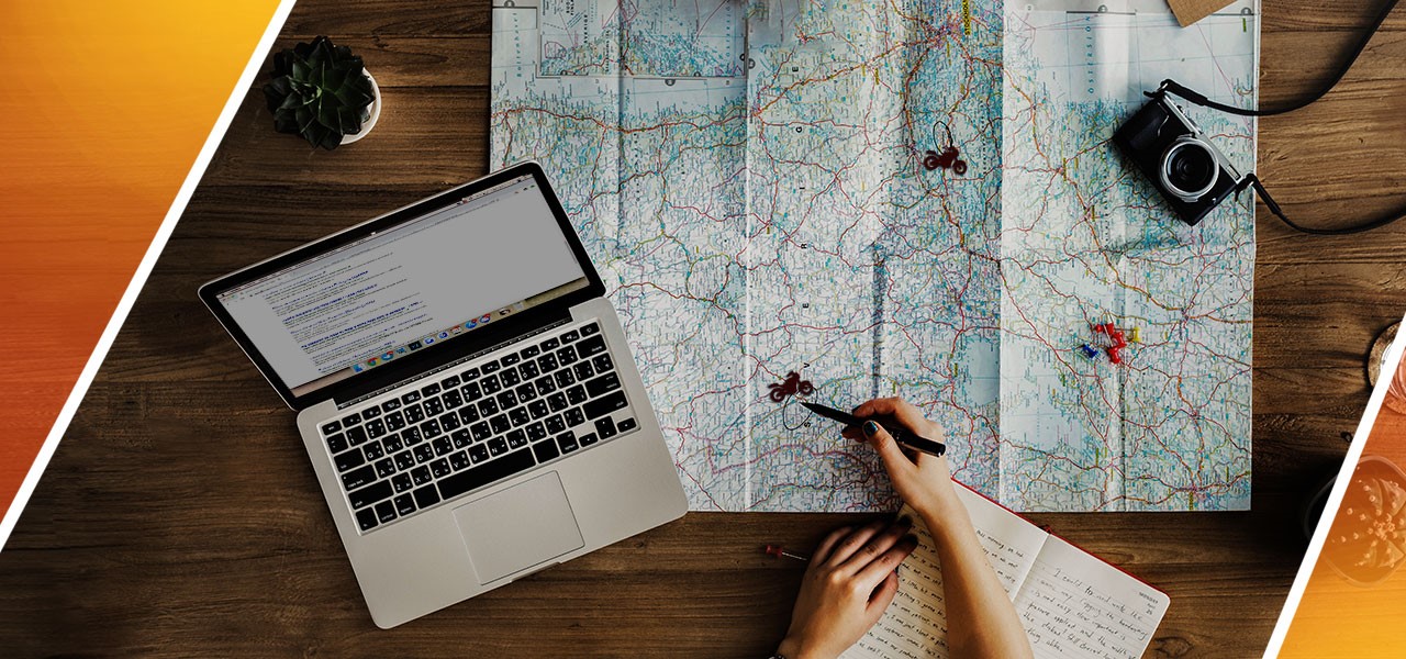 Encima de una mesa hay un mapa con la localización de unas motos marcadas, al lado un ordenador y una cámara de fotos