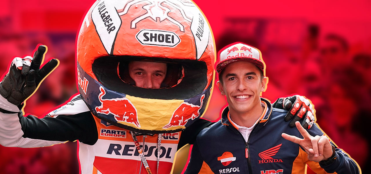 Marc Márquez agarra del hombro a un fan vestido con un mono Repsoly un casco gigante de papel maché