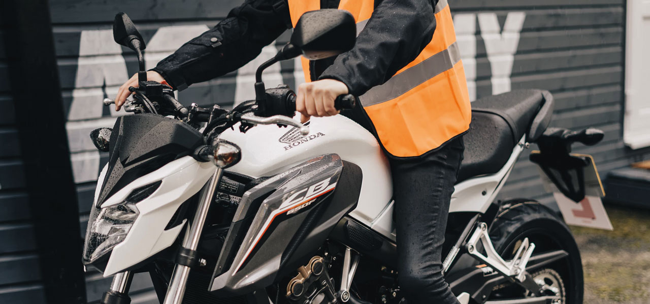 un motorista con un chaleco naranja de seguridad