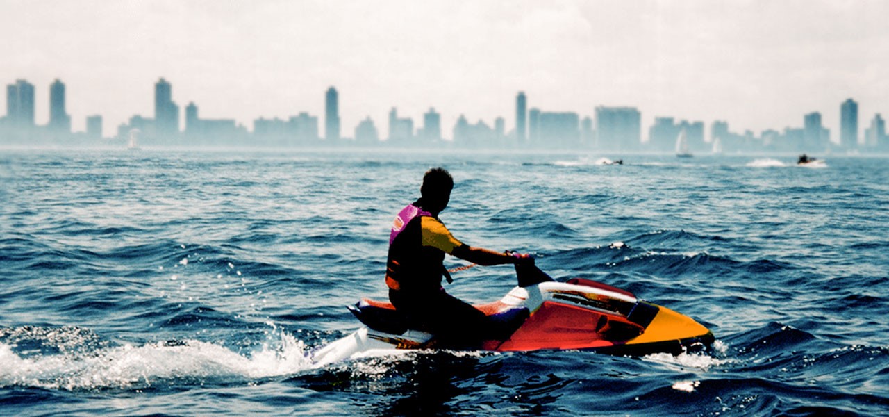 moto de agua repsol honda en la superficie del agua con ciudad de fondo