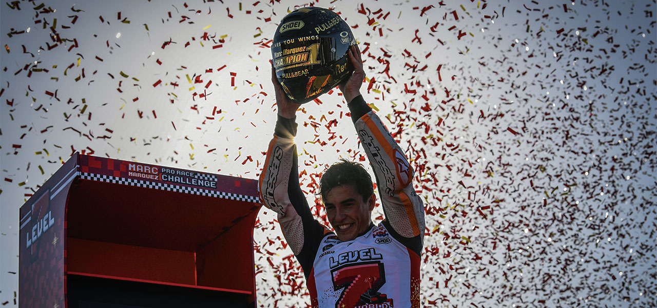 Marc Márquez sostiene el casco dorado de campeón frente a la recreativa de level 7