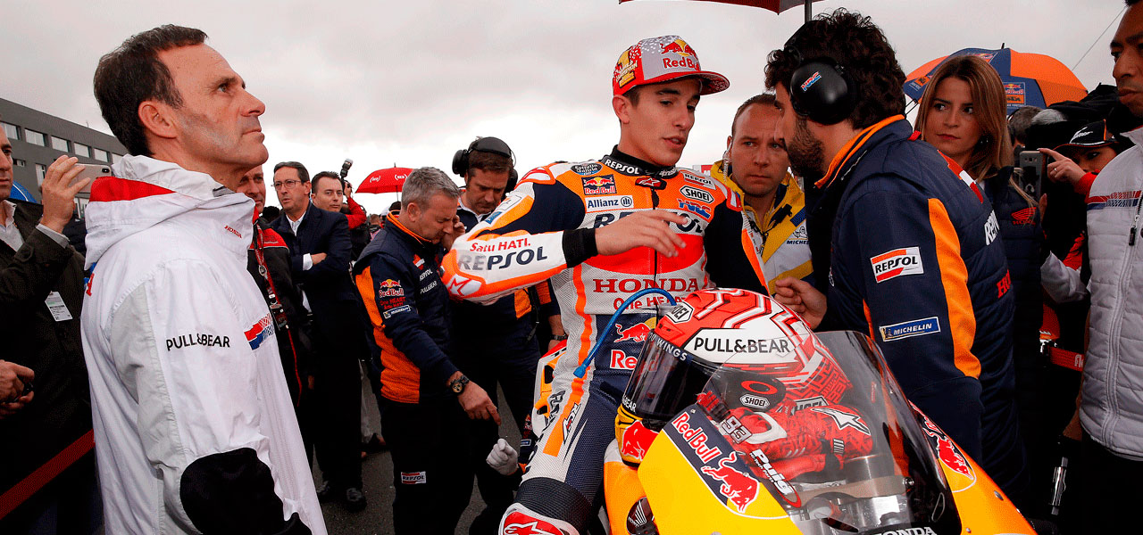 Alberto Puig con Marc Márquez y Santi Hernández en el pit lane