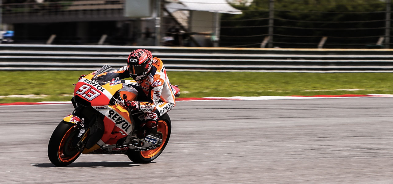 Marc Márquez se acerca a una curva y de fondo vemos las gradas del gran premio de Malasia