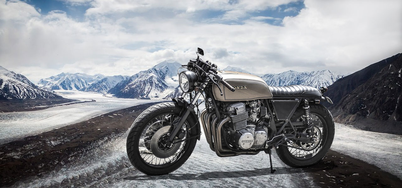 honda de lado en una carretera con nieve y montañas heladas de fondo