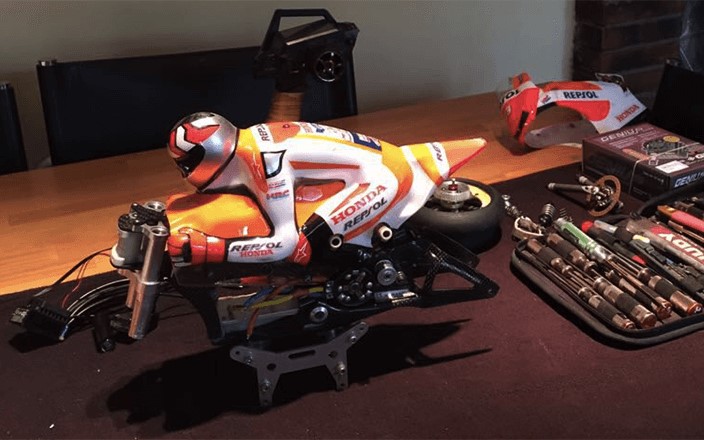 Encima de una mesa vemos la parte superior de una moto de radiocontrol de Marc Márquez