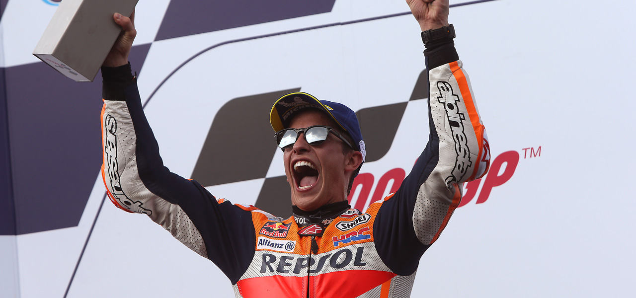 Marc Márquez con los brazos alzados en un podio