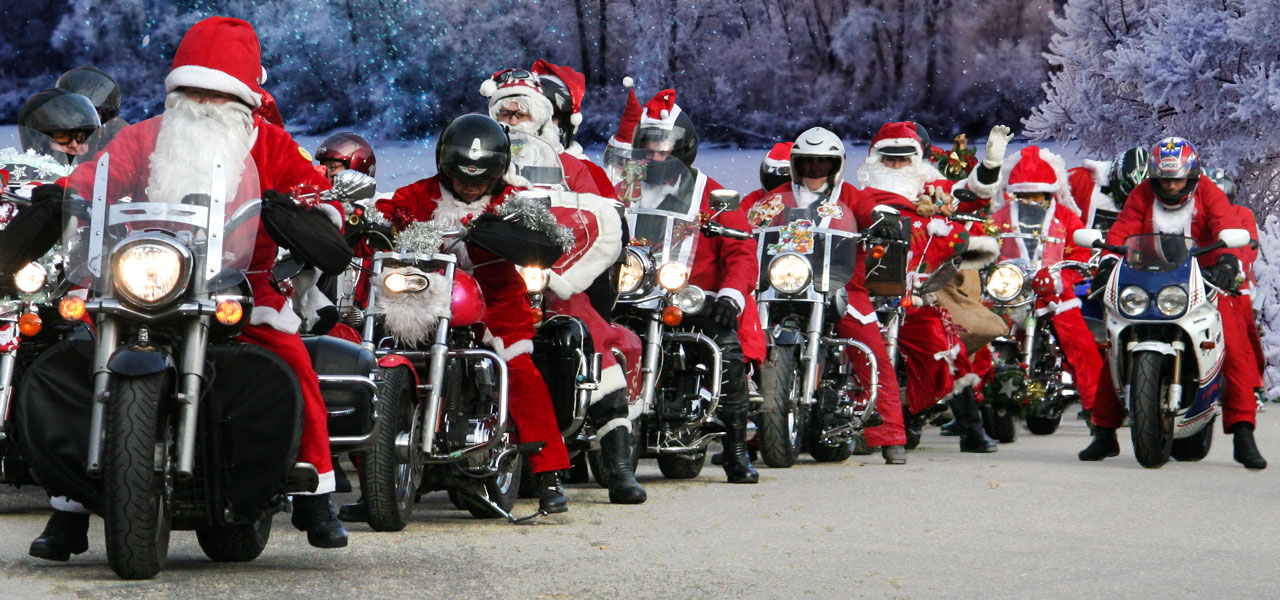 Papanoelada motera con muchos motoristas en cabalgata vestidos de Papa Noel