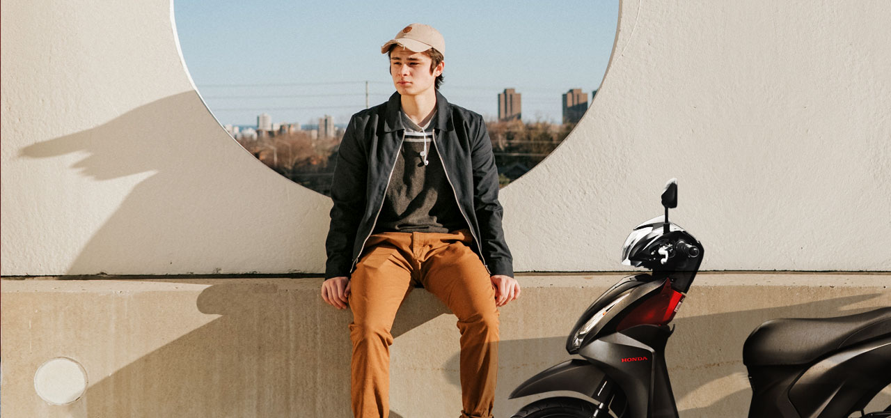 joven junto a su primera moto de 50 cc