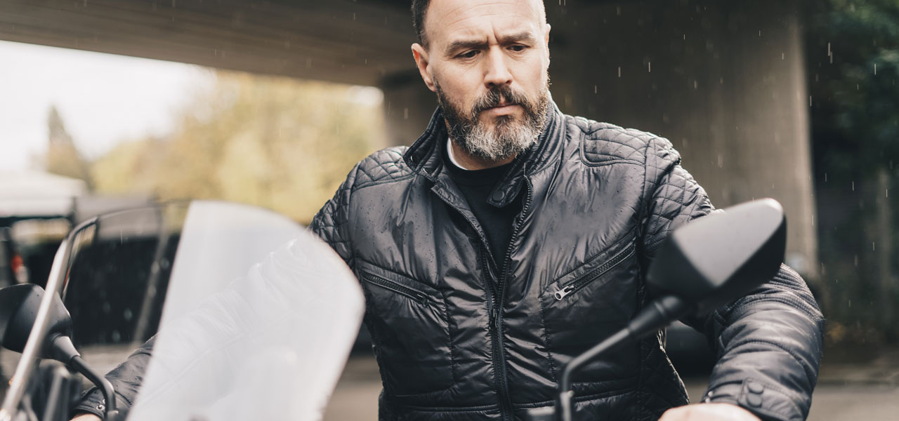 un motero curtido observa su moto antes de ponerse el casco