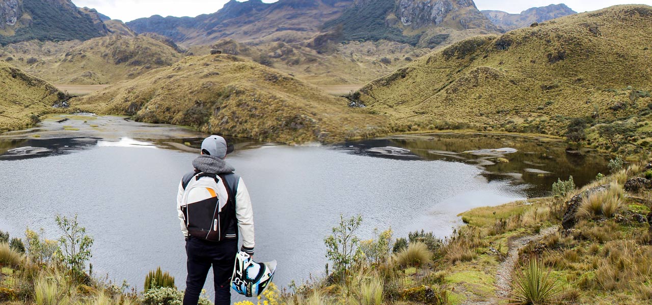 Motero mira las mágnificas vistas naturales de un lago