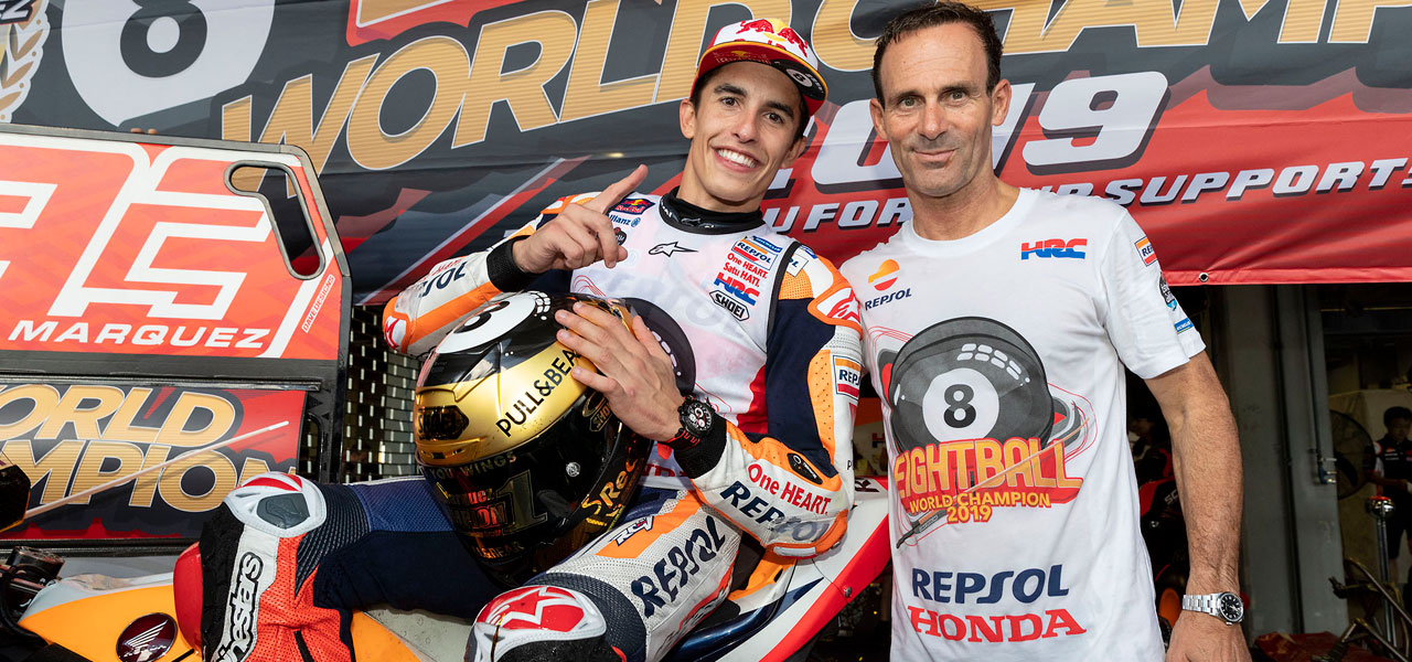 Marc Márquez y Alberto Puig con camisetas de campeón
