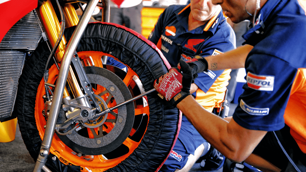 Técnicos Repsol Honda ajustando la rueda de la RC213V