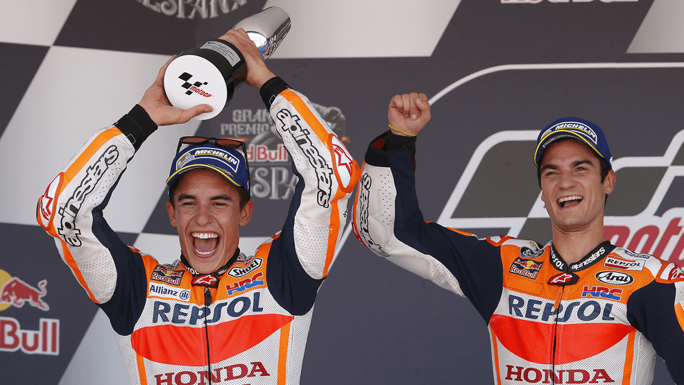 Marc Márquez levantando un trofeo junto a Dani Pedrosa en el podio