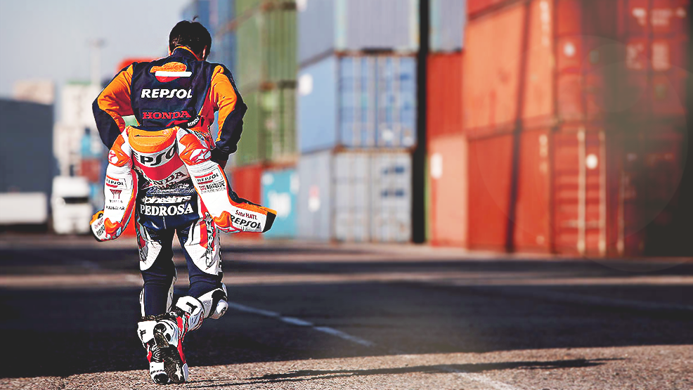 Dani Pedrosa de espalda quitándose mono repsol honda en almacén contenedores